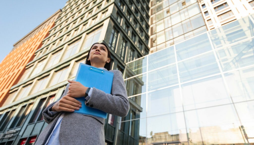 low angle businesswoman holding clipboard city 1500x856 1